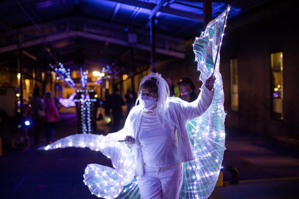 Susan Moore dances in her winged costume under the shed as the music plays from a speaker during FoolMoon festival in Kerrytown of Ann Arbor, Friday, April 9, 2021.