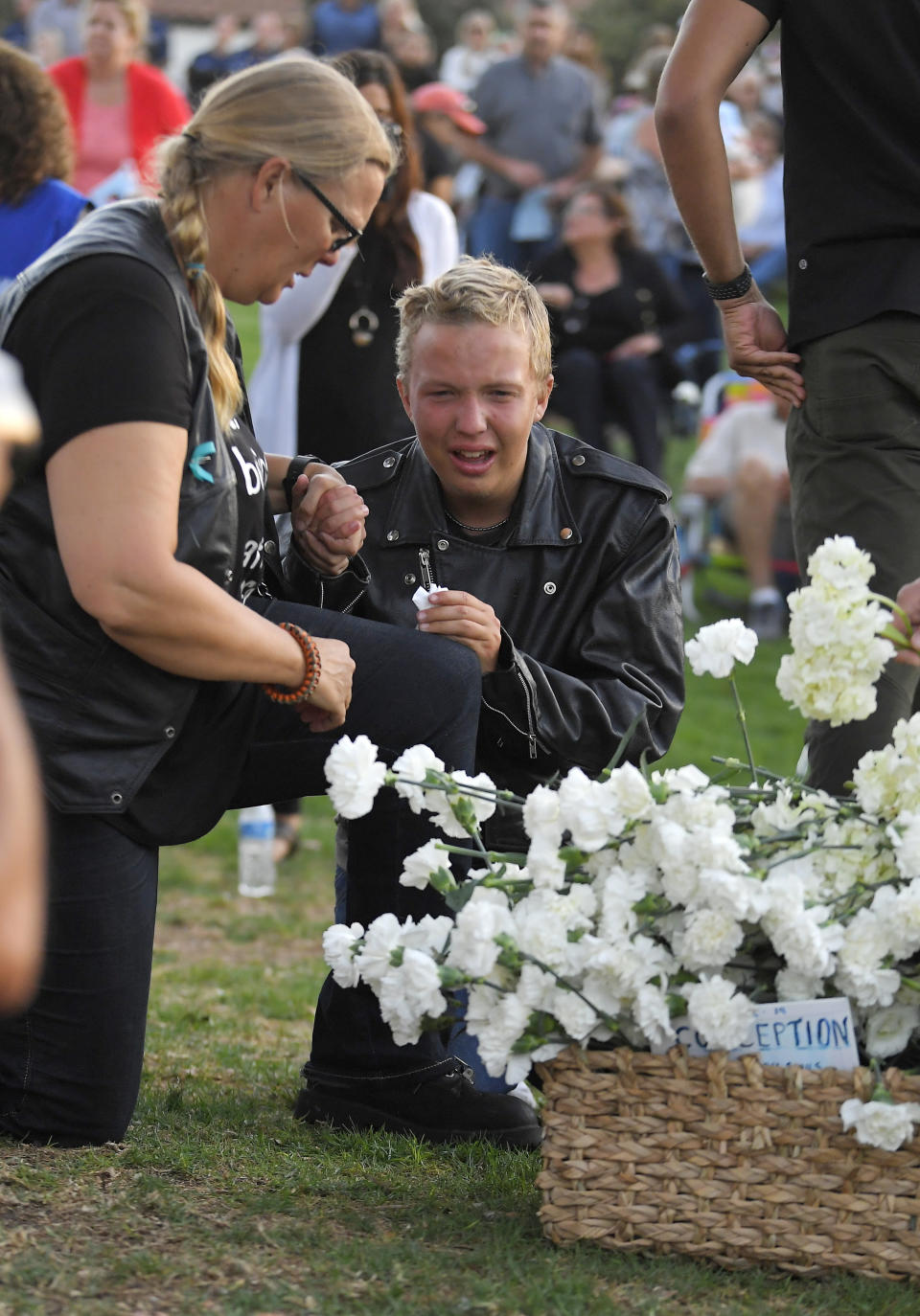 Bethany Holt, left, kneels with her son Jimmy, 15, during a vigil Friday, Sept. 6, 2019, in Santa Barbara, Calif. for the victims who died aboard the dive boat Conception. The Sept. 2 fire took the lives of 34 people on the ship off Santa Cruz Island off the Southern California coast near Santa Barbara. (AP Photo/Mark J. Terrill)