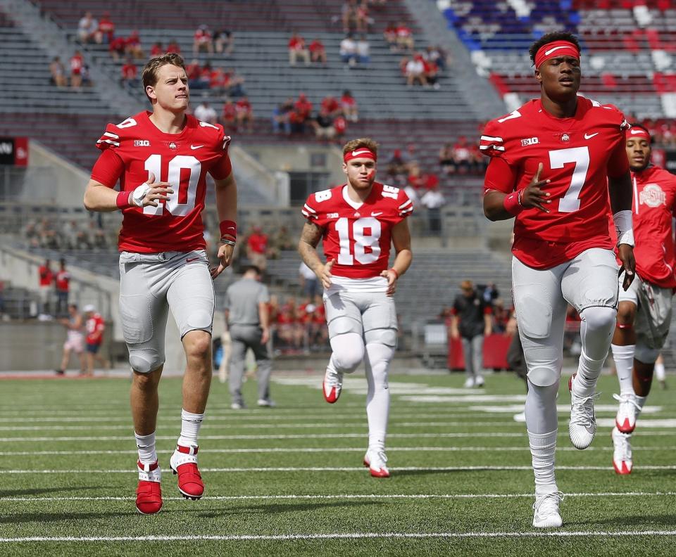 Ohio State Buckeyes quarterbacks, from left, Joe Burrow, Tate Martell and Dwayne Haskins warm up prior to the NCAA football game against the Army Black Knights at Ohio Stadium in Columbus on Sept. 16, 2017. [Adam Cairns / Dispatch]