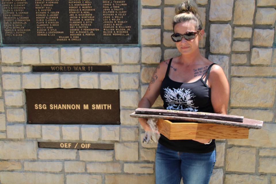 Kristi Smith, sister of Staff Sgt. Shannon M. Smith of Marion who was killed during Operation Iraqi Freedom in 2009, poses next to the new plaque honoring her brother. A ceremony to unveil the plaque was held on Memorial Day at the Marion County Courthouse. The plaque is located on the western wall of the courthouse that faces Main Street. Sgt. Smith died on Sept. 8, 2009, when a vehicle he was riding in was bombed by enemy forces near Baji, Iraq.