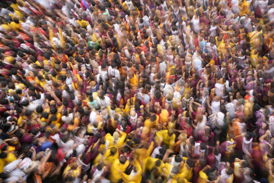 Devotees join the annual Black Nazarene procession which was resumed after a three-year suspension due to the coronavirus pandemic on Tuesday, Jan. 9, 2024 in Manila, Philippines. A mammoth crowd of mostly barefoot Catholic devotees joined a chaotic procession through downtown Manila Tuesday to venerate a centuries-old black statue of Jesus Christ with many praying for peace in the Middle East where Filipino relatives work. (AP Photo/Aaron Favila)