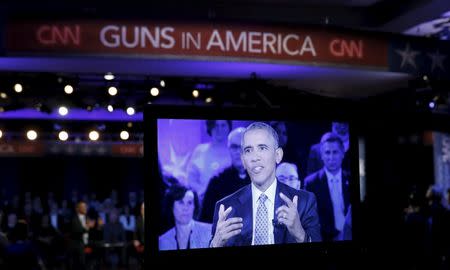 U.S. President Barack Obama is seen on a monitor as he speaks during a live town hall event on reducing gun violence hosted by CNNâ€™s Anderson Cooper at George Mason University in Fairfax, Virginia January 7, 2016. REUTERS/Kevin Lamarque