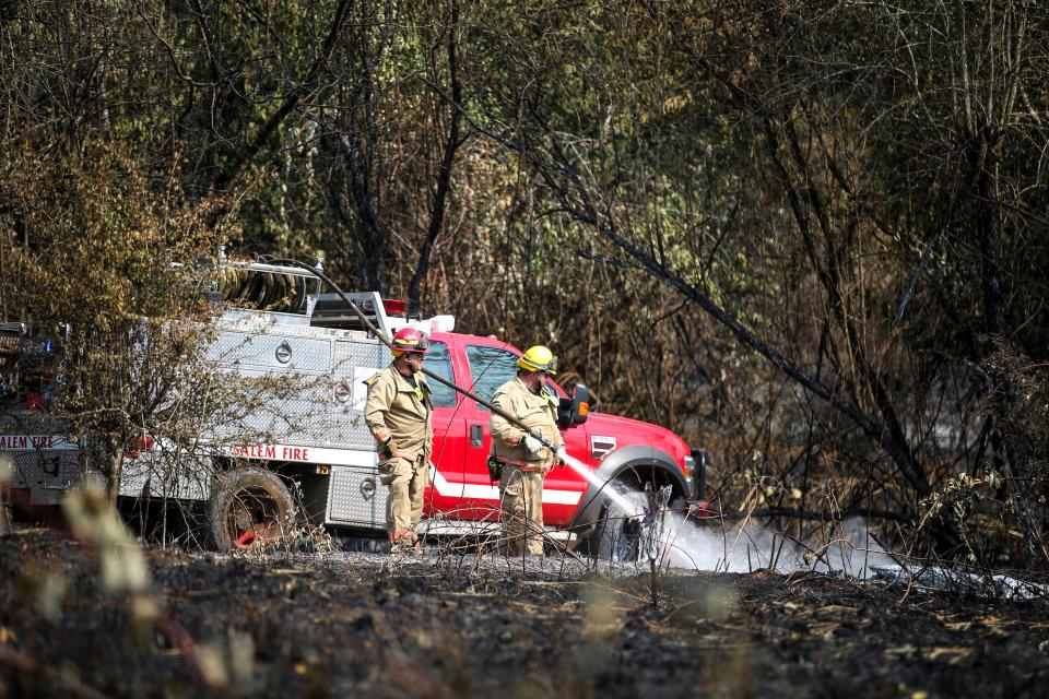 Firefighters with the Salem Fire Department use a brush truck to mop up an area near Jory Hill Road S. the day after the Aug. 23 Liberty Fire.