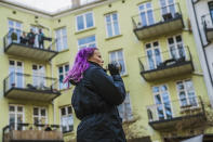 Anna Nohr speaks using a loud speaker as she invites her neighbours to take part in a backyard quiz, in Oslo, Norway, Monday, March 23, 2020, as people stay in the wake of the coronavirus. (Stian Lysberg Solum /NTB scanpix via AP)