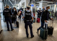 FILE - In this March 30, 2021, file photo, German federal police officers check passengers arriving from Palma de Mallorca for a negative Corona test as they arrive at the airport in Frankfurt, Germany. Germany will require people entering the country who haven’t been vaccinated or recently recovered from COVID-19 to show a negative test result starting from Sunday. (AP Photo/Michael Probst, File)