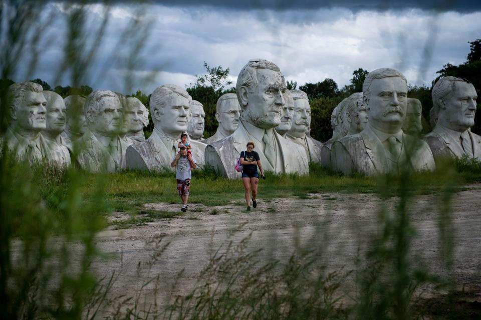 People walk past decaying busts of former US Presidents near the mulching facility where they now reside on August 25, 2019, in Williamsburg, Virginia. (Photo: Brendan Smialowski/AFP/Getty Images)
