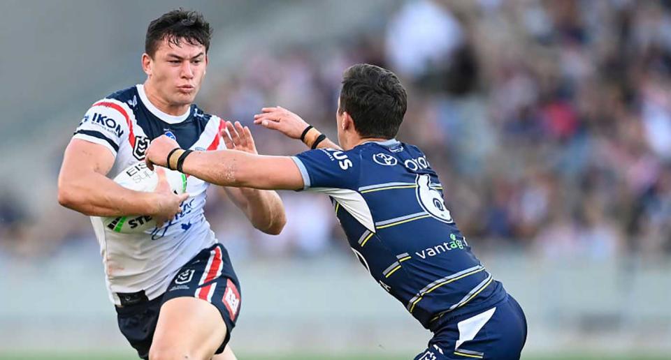 Joseph Manu of the Roosters is tackled by Scott Drinkwater of the Cowboys during the round 18 NRL match between the North Queensland Cowboys and the Sydney Roosters at QCB Stadium in Townsville.