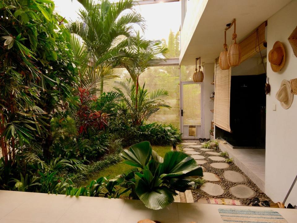 A pathway leading to the front door of the house. There's a garden inside the house.