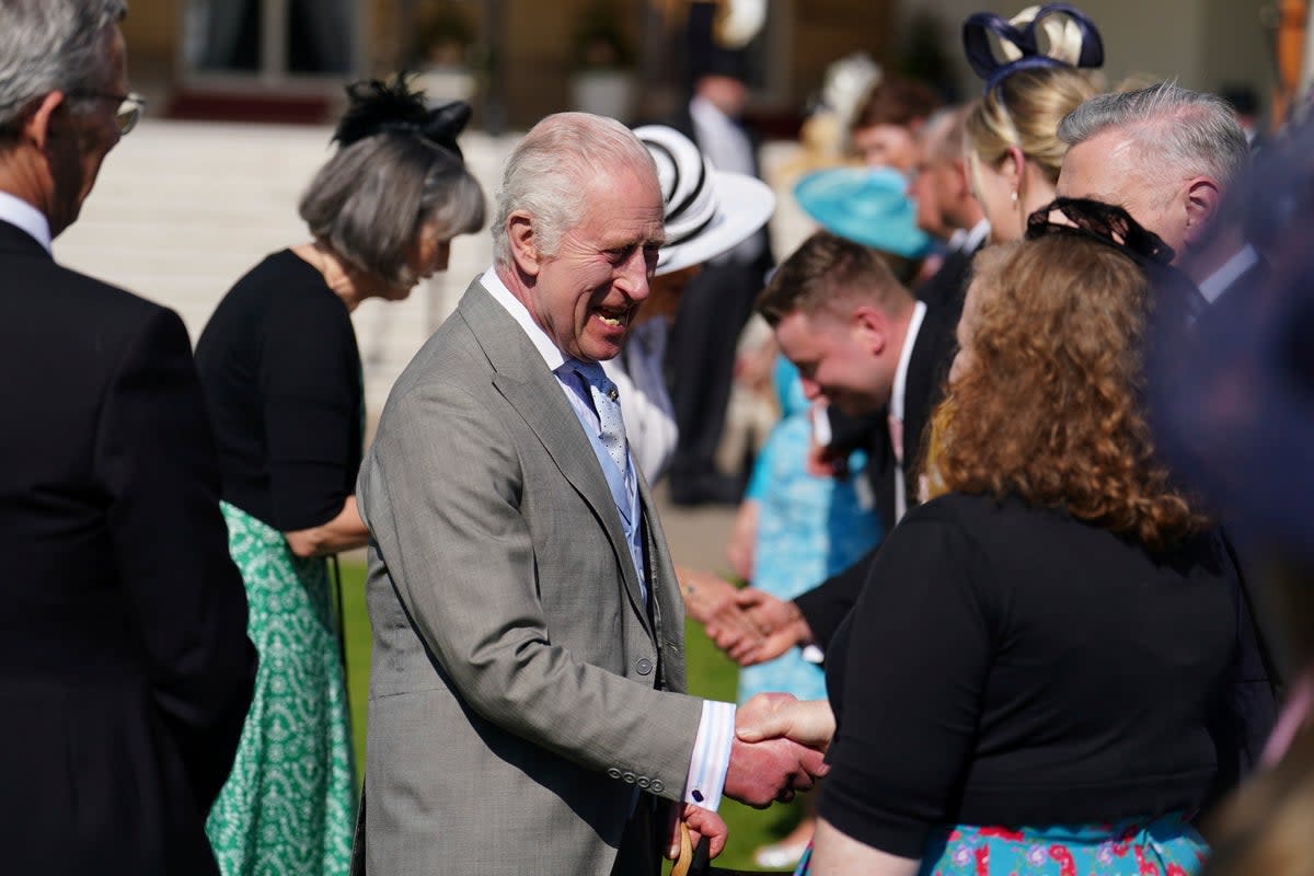 King Charles III speaks to guests attending a Royal Garden Party at Buckingham Palace (AP)
