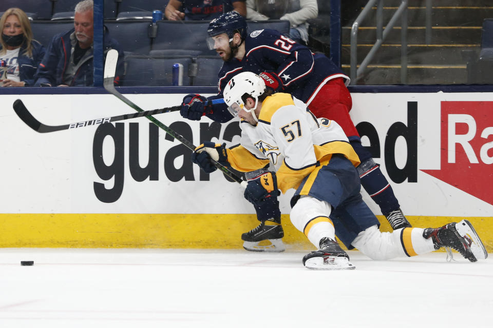 Columbus Blue Jackets' Oliver Bjorkstrand, top, passes the puck as Nashville Predators' Dante Fabbro defends during the second period of an NHL hockey game Wednesday, May 5, 2021, in Columbus, Ohio. (AP Photo/Jay LaPrete)