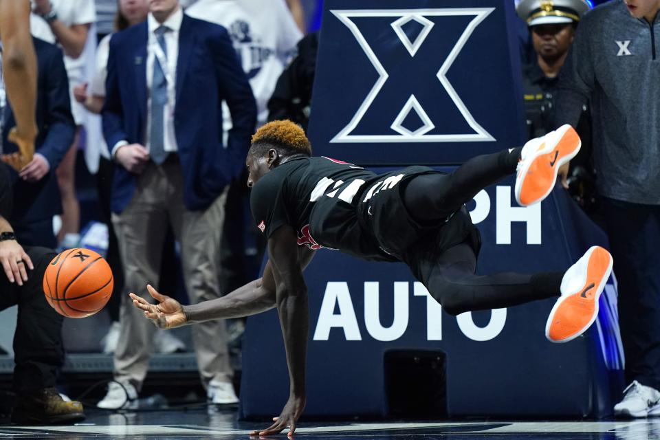 Cincinnati Bearcats forward Aziz Bandaogo (55) saves the ball from going out of bounds in the first half of the 91st Crosstown Shootout basketball game between the Cincinnati Bearcats and the Xavier Musketeers, Saturday, Dec. 9, 2023, at Cintas Center in Cincinnati. The Xavier Musketeers won, 84-79.