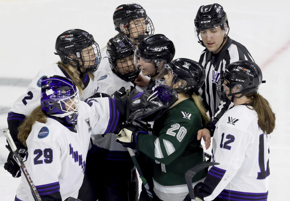 Game officials break up a scuffle between Minnesota players including goalie Nicole Hensley (29) and Boston players, including Boston forward Hannah Brandt (20) during the third period of Game 2 of a PWHL hockey championship series, Tuesday, May 21, 2024, in Lowell, Mass. (AP Photo/Mark Stockwell)
