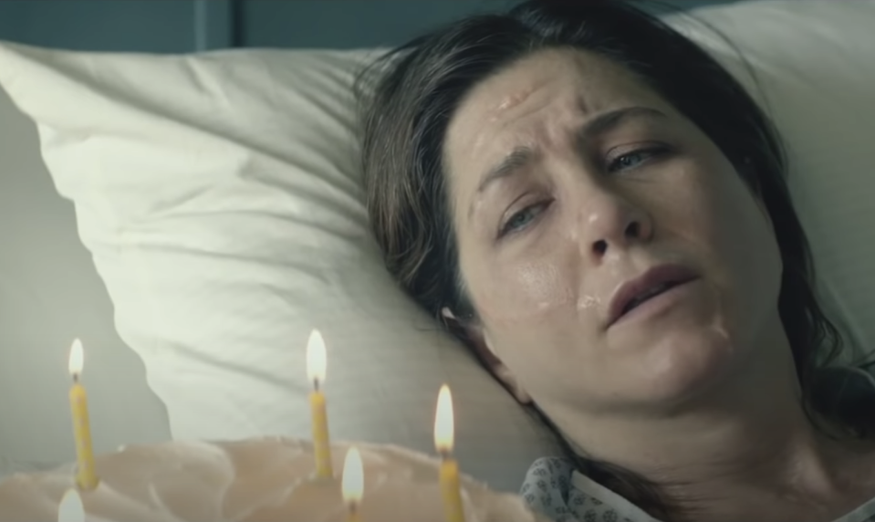 Jennifer aniston sweating miserably in a hospital bed and looking at a birthday cake in cake