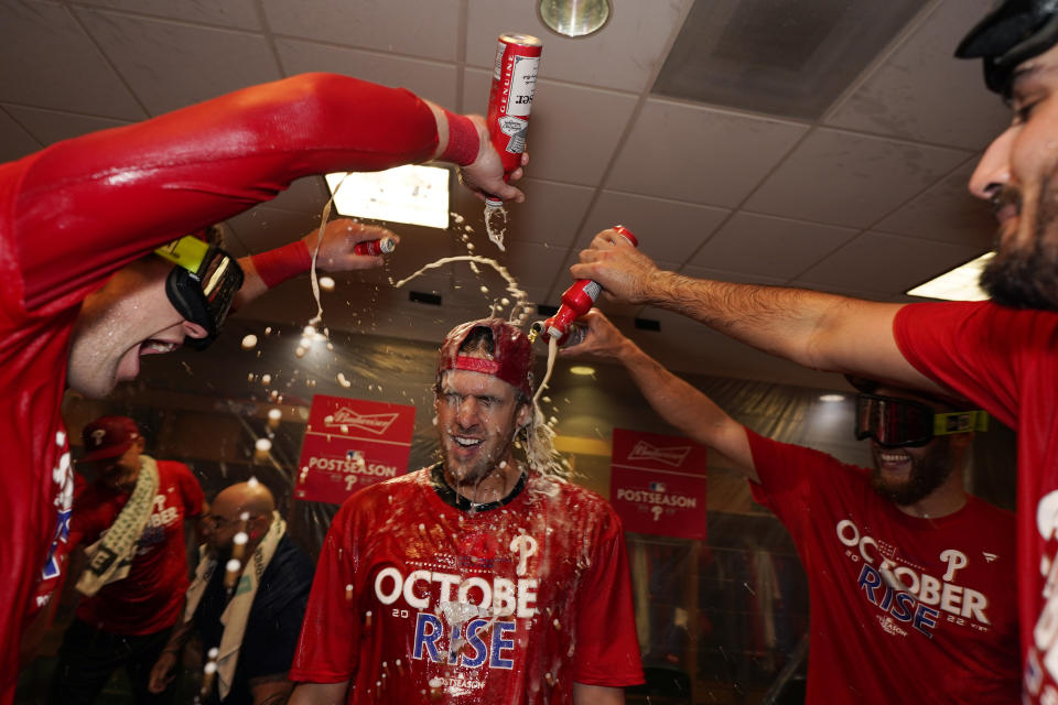 Philadelphia Phillies&#39; Aaron Nola, center, celebrates with teammates after the Phillies won a baseball game against the Houston Astros to clinch a wild-card playoff spot, Monday, Oct. 3, 2022, in Houston. (AP Photo/David J. Phillip)