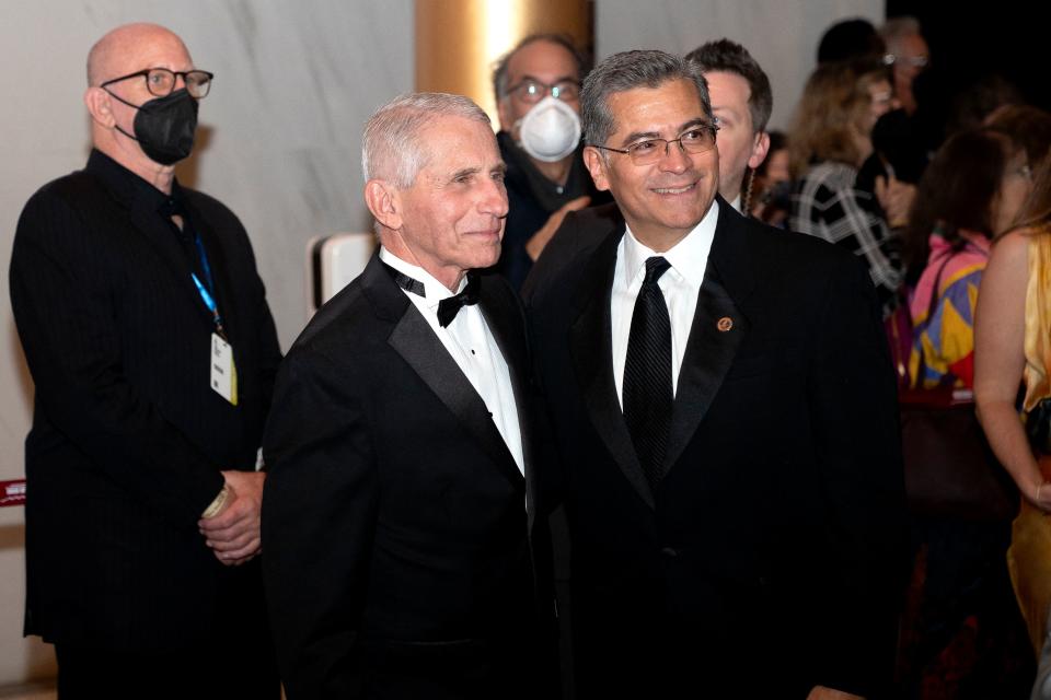 Dr. Anthony Fauci and Health and Human Services Secretary Xavier Becerra smile for a photographer.