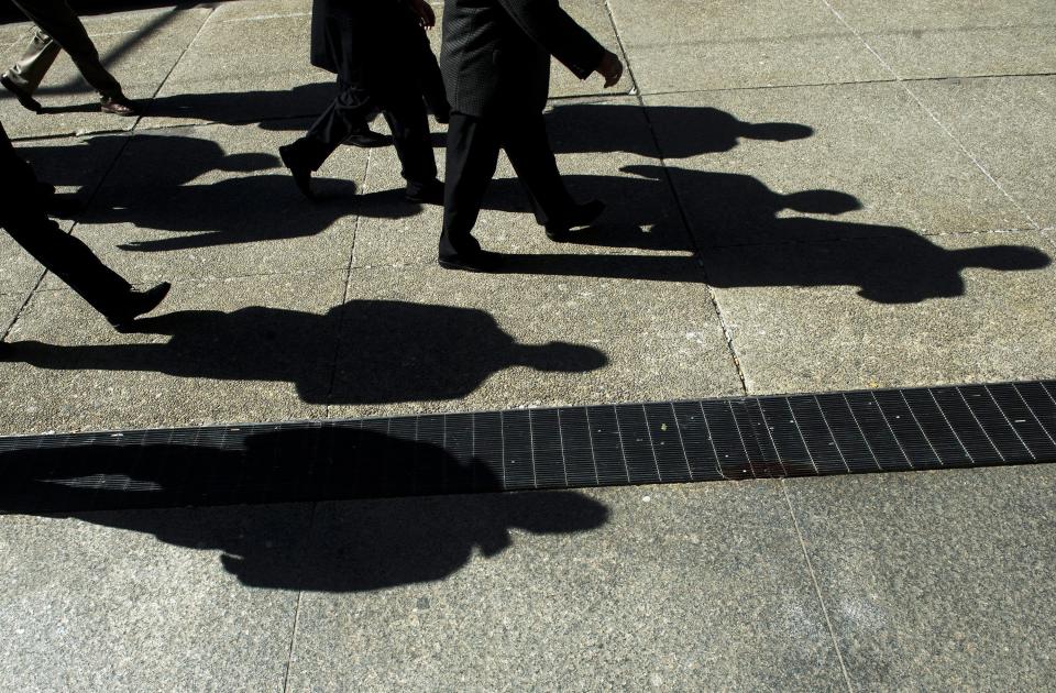 Businessmen cast their shadows as they walk inToronto's financial district on Monday, Feb. 27, 2012. A Scotiabank retirement survey says more than half of Canadians are concerned that financial pressure will force them to re-enter the workplace after they retire. THE CANADIAN PRESS/Nathan Denette