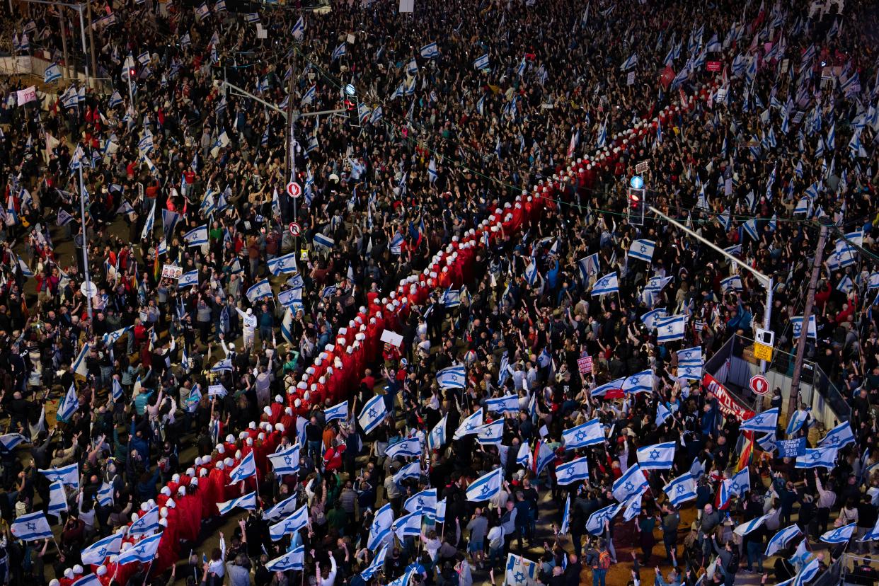 A line of protesters supporting women’s rights, dressed as characters from The Handmaid’s Tale (Copyright 2023 The Associated Press All rights reserved)