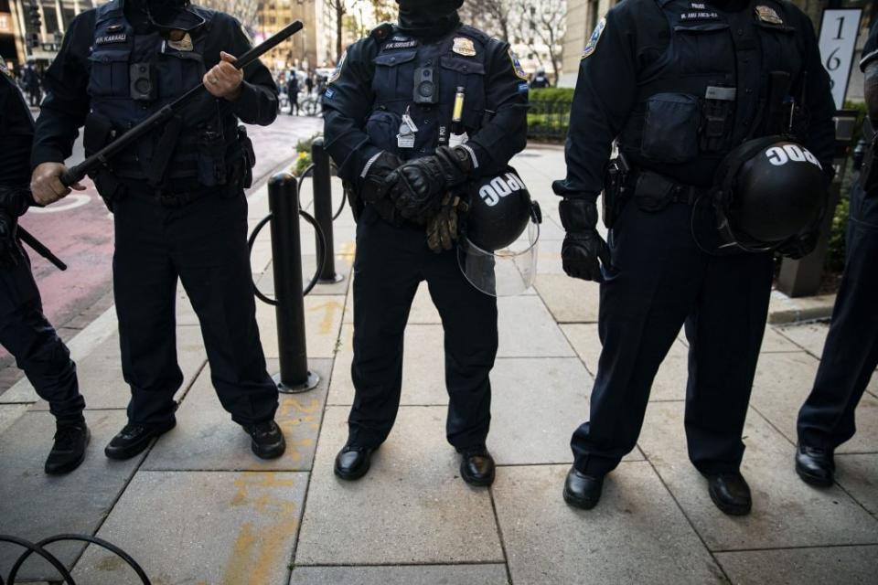 Members of the Metropolitan Police Department stand guard as they separate counter-protesters from supporters of President Trump near Black Lives Matter Plaza, on December 12, 2020 in Washington, DC. (Photo by Al Drago/Getty Images)