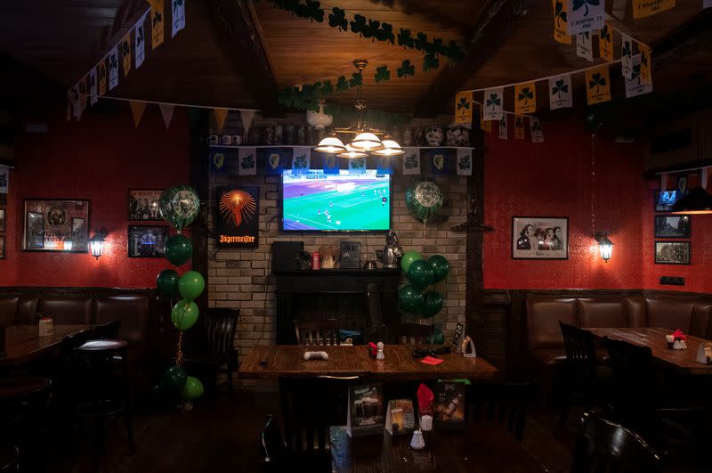 A TV set broadcasting the soccer match of the Belarusian Premier League is seen at a bar in Moscow