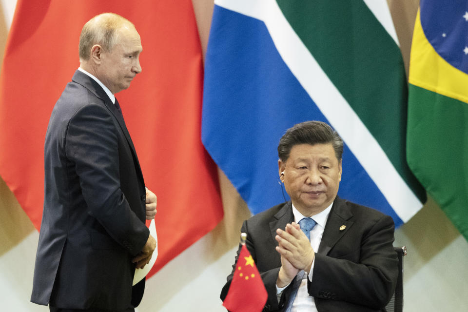 China's President Xi Jinping, right, and Russia's President Vladimir Putin attend a meeting with members of the Business Council and management of the New Development Bank during the BRICS emerging economies at the Itamaraty palace in Brasilia, Brazil, Thursday, Nov. 14, 2019. (AP Photo/Pavel Golovkin, Pool)