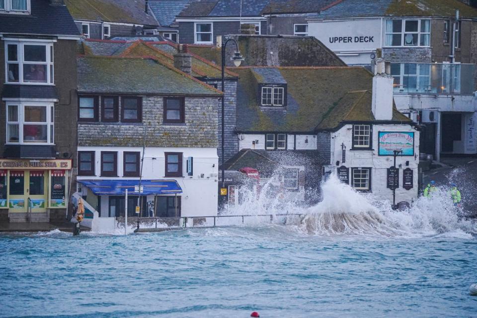Waves strike the harbourside in St Ives, Cornwall (Getty)