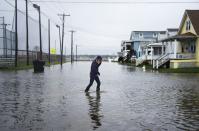 A woman crosses a flooded street in Ocean City, Maryland, on October 3, 2015