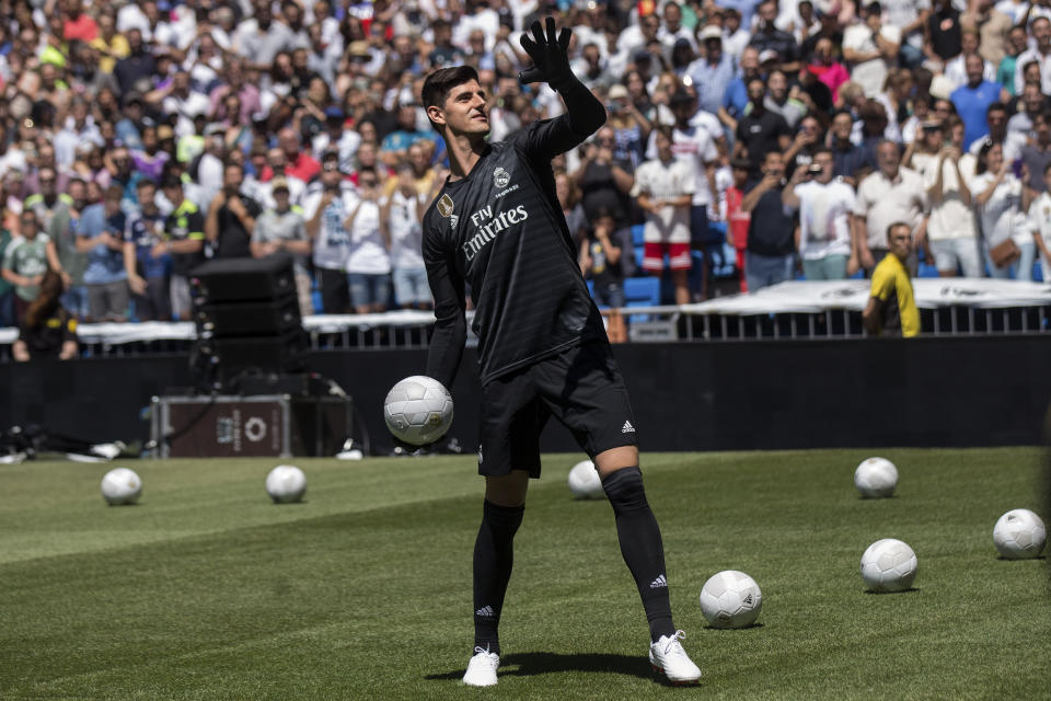 Belgian new Real Madrid soccer player Thibaut Courtois throws a ball to Real Madrid supporters during his official presentation for Real Madrid at the Santiago Bernabeu stadium in Madrid, Thursday, Aug. 9, 2018. Chelsea has sold a player — goalkeeper Thibaut Courtois — to Real Madrid. The Belgian was replaced by Kepa Arrizabalaga after Chelsea met the goalkeeper's 80 million euro ($93 million) buyout clause from Athletic Bilbao on Wednesday. (AP Photo/Andrea Comas)