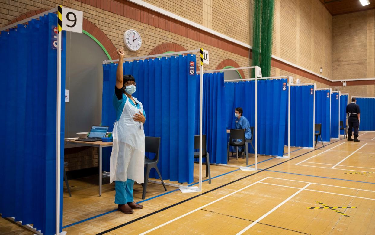 A health worker signals to a colleague that she is available to administer the AstraZeneca Covid-19 vaccine - Matthew Horwood /Getty Images Europe 