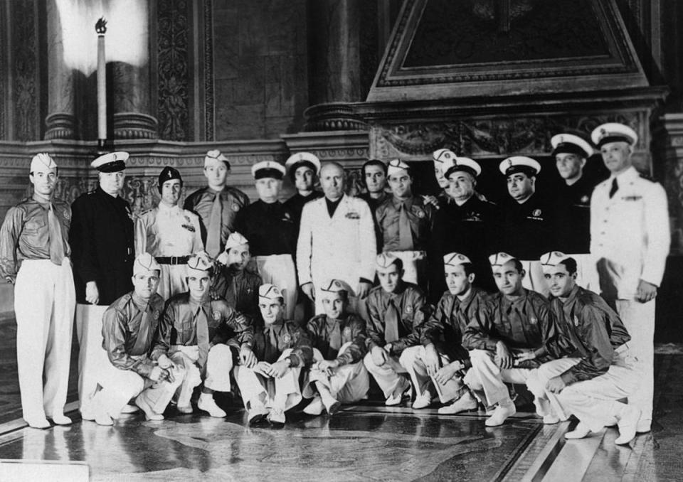 Benito Mussolini, in white, receives the Italian World Cup team. Giuseppe Meazza, the captain, stands to the right of the Duce (AFP via Getty Images)