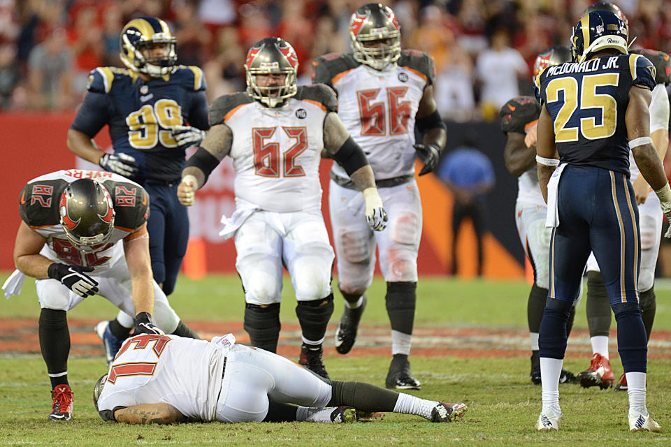 Sep 14, 2014; Tampa, FL, USA; Tampa Bay Buccaneers wide receiver Mike Evans (13) lays on the ground after getting hit by St. Louis Rams defensive back T.J. McDonald (25) on the last play of the game at Raymond James Stadium. (Jonathan Dyer-USA TODAY Sports)