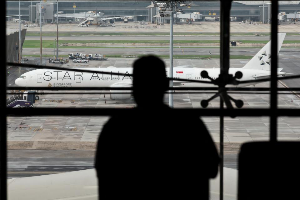 A person stands as the Singapore Airlines aircraft for flight SQ321 is parked on the tarmac after an emergency landing at Suvarnabhumi International Airport, in Bangkok, Thailand, 22 May 2024 (Reuters)