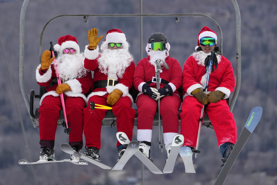 Skiers dressed in Santa Claus outfits ride a chairlift at the Sunday River Ski Resort, Sunday, Dec. 11, 2022, in Newry, Maine. The skiing Santas raise money for the River Fund, a non-profit organization that supports youth education and recreation in the Bethel, Maine area. (AP Photo/Robert F. Bukaty)