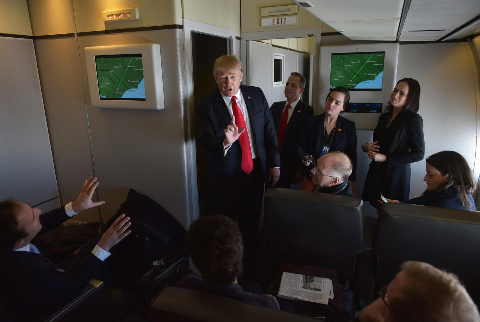 President Donald Trump chats with reporters on board Air Force One before departing from Andrews Air Force Base.