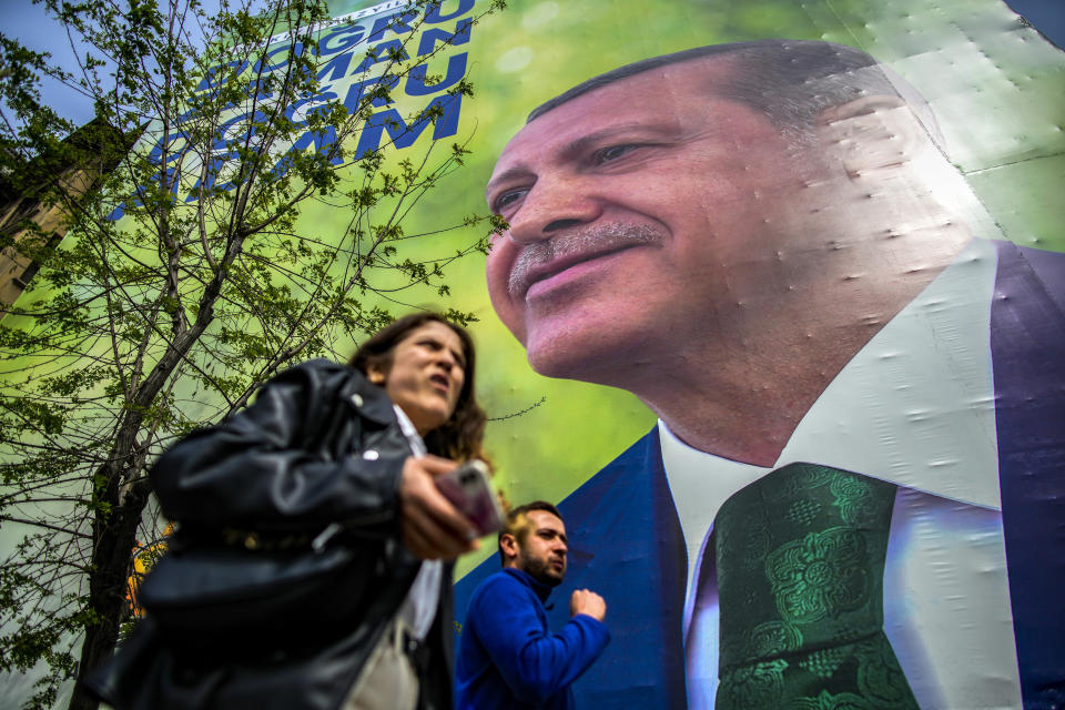 Pedestrians walk past an election campaign billboards of Turkish President and People's Alliance's presidential candidate Recep Tayyip Erdogan in Istanbul, Turkey, Thursday, May 4, 2023. (AP Photo/Emrah Gurel)