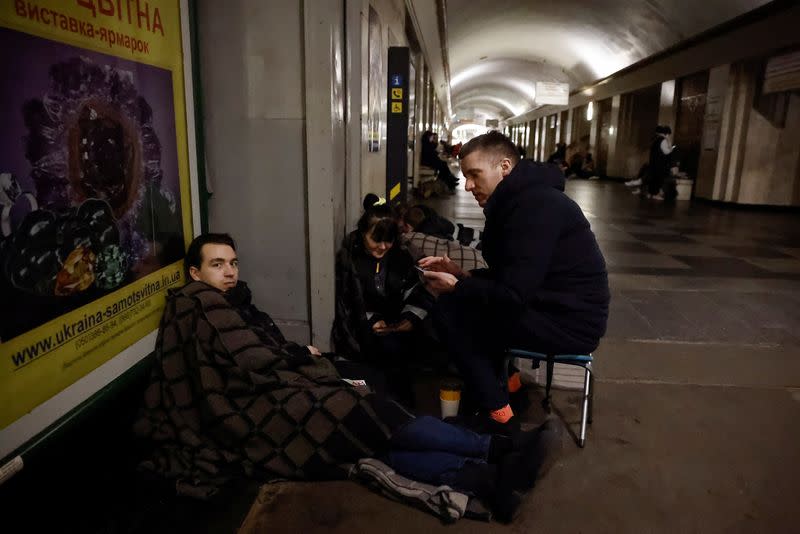 People take shelter in a metro station during a Russian missile strike, in Kyiv