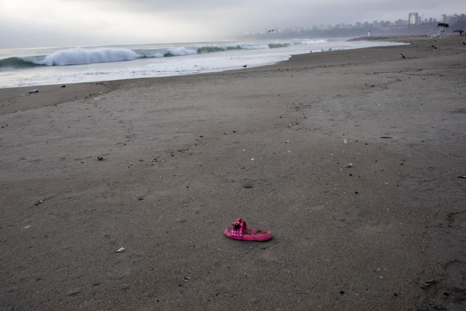 This March 25, 2020 photo shows a lone sandal on the shore of Agua Dulce beach that is typically packed to the gills this time of year, in Lima, Peru. (AP Photo/Rodrigo Abd)