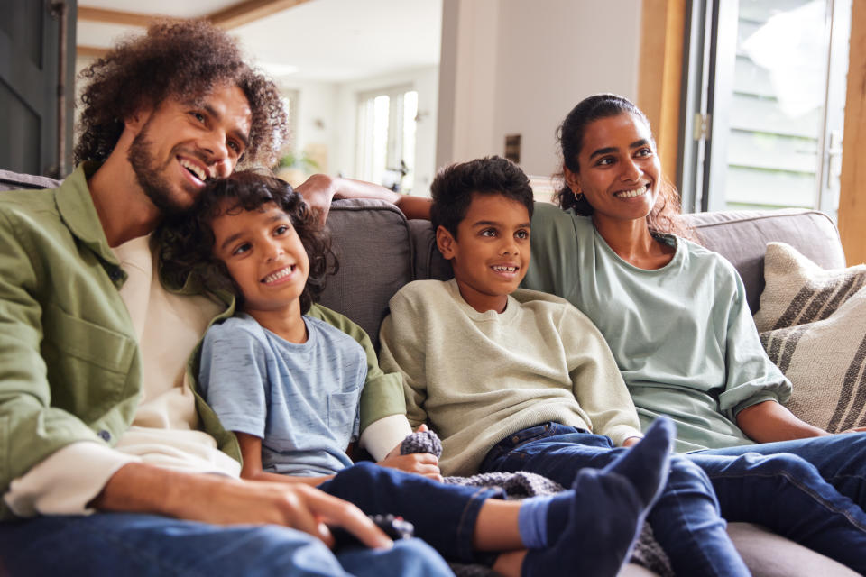 Family watching TV at home on sofa