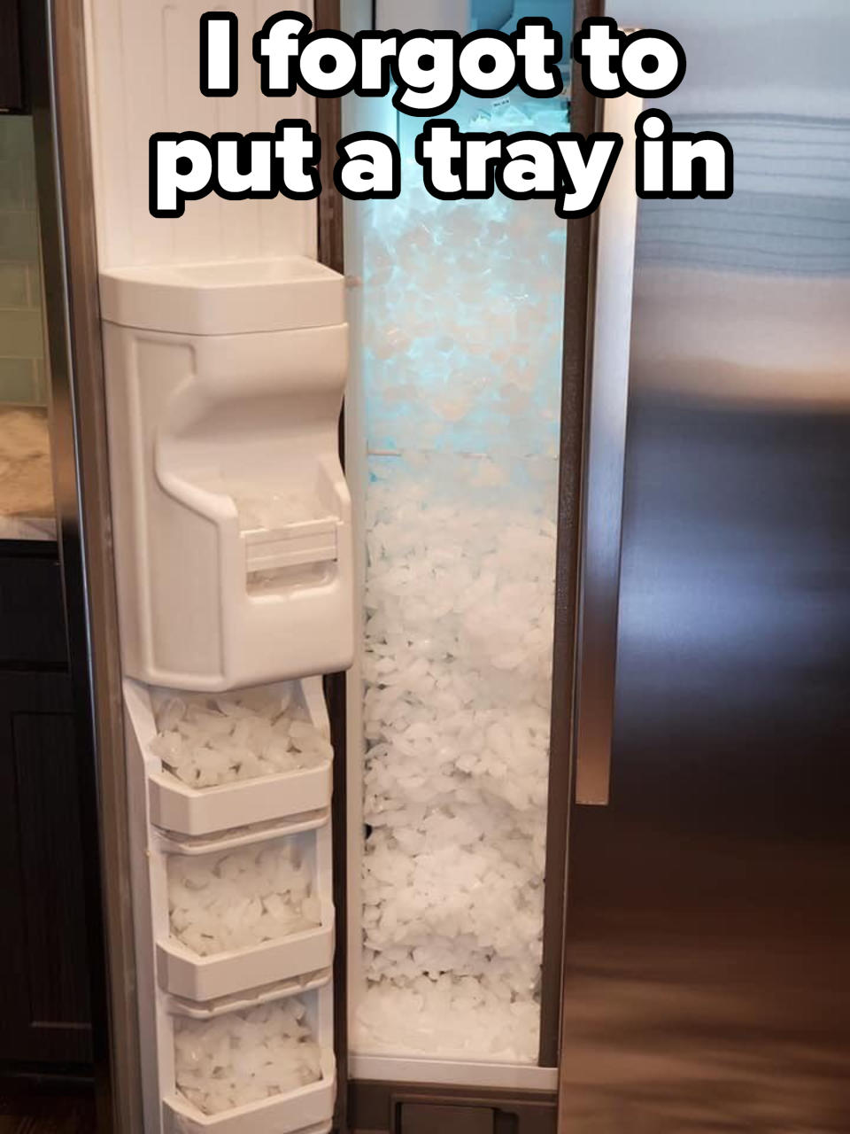 Refrigerator with an overstuffed ice dispenser, ice spilling out into interior, because person didn't put a tray in