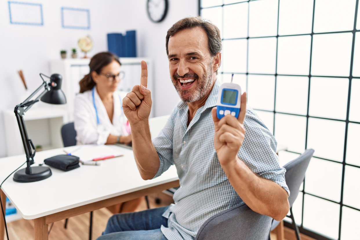 Happy Diabetic With Testing Device Turned to the Camera