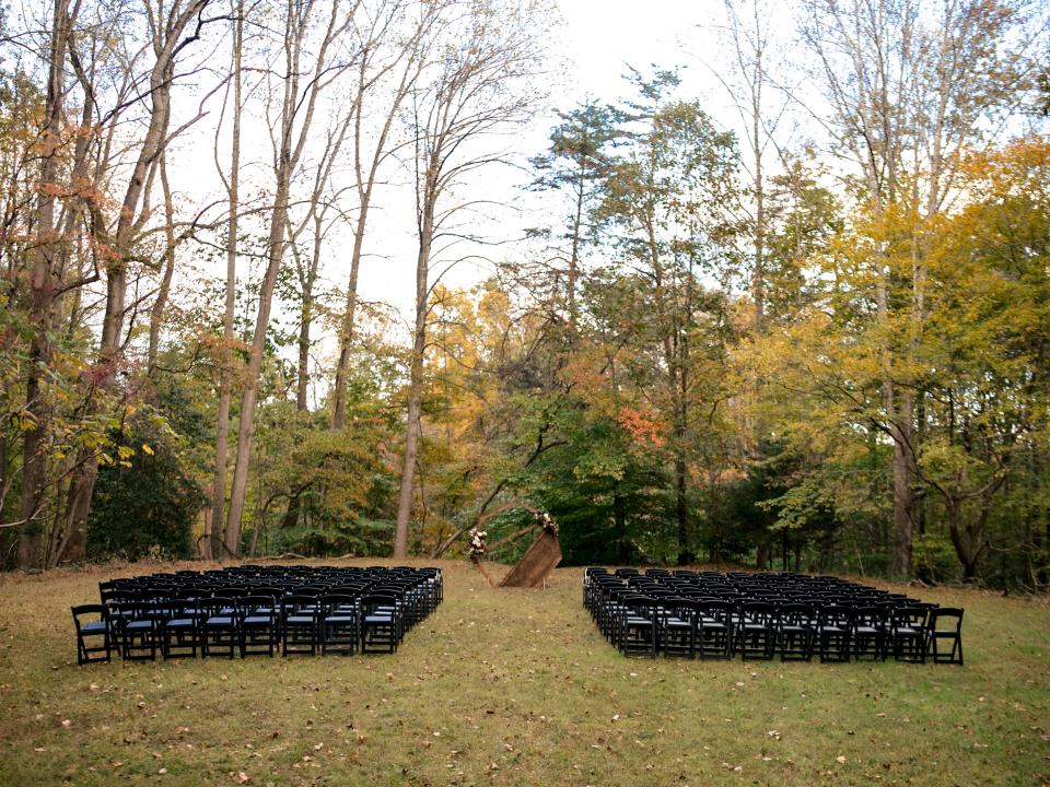 A view of the ceremony space outside, with chairs and a wooden arch