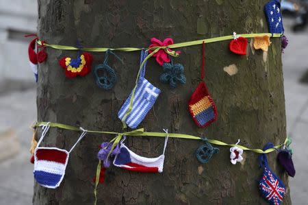 Knitted European flags hang from a ribbon tied around a tree during a protest in favour of amendments to the Brexit Bill outside the Houses of Parliament, in London, Britain, March 13, 2017. REUTERS/Neil Hall