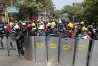 Anti-coup protesters with makeshift shields take positions in Mandalay, Myanmar, Tuesday, March 9, 2021. Demonstrators in Myanmar's biggest city of Yangon came out Monday night for their first mass protests in defiance of an 8 p.m. curfew, seeking to show support for an estimated 200 students trapped by security forces in a small area of one neighborhood. (AP Photo)