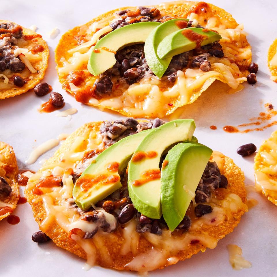 tostadas topped with black beans, cheese, and avocado slices