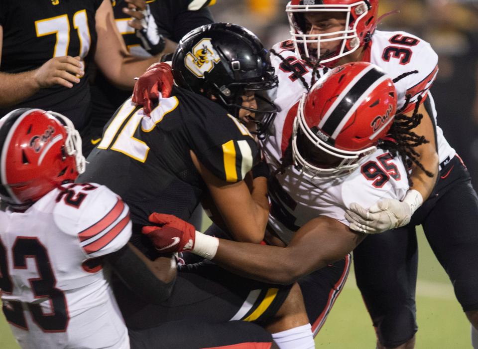 The Brandon defense Khalil Norwood (23), Deaunde Washington (95) and Jacob Toro (36) crush Starkville quarterback Trey Petty III (12) during the MHSAA 6A State Championship Gridiron Classic at M.M. Roberts Stadium at the University of Southern Mississippi in Hattiesburg, Miss., Saturday, Dec. 3, 2022. Starkville went on to win 48-32.