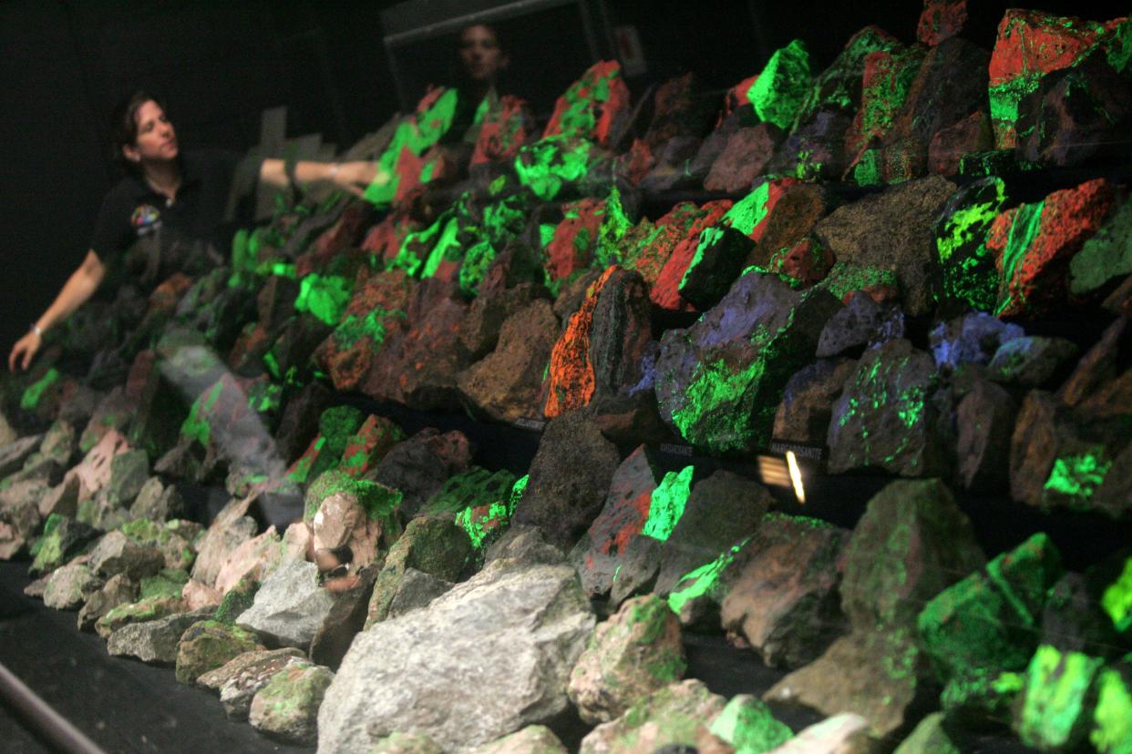 A guide at the Franklin Mineral Museum shows how rocks shine under a black light in the Fluorescent Minerals Room.