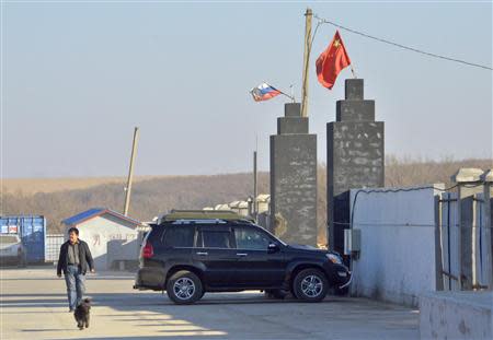 A man walks past the gates of the "Armada" farming project run by Dongning Huaxin Group near the far eastern Russian town of Ussuriysk November 13, 2013. REUTERS/Yuri Maltsev