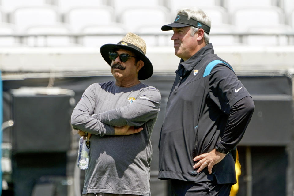 Jacksonville Jaguars owner Shad Khan, left, and head coach Doug Pederson watch players perform drills at an NFL football practice, Monday, June 13, 2022, in Jacksonville, Fla. (AP Photo/John Raoux)