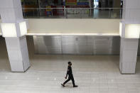 A lone man wearing a protective face mask walks in a mall along the Orchard Road shopping belt in Singapore, Friday, April 10, 2020. The Singapore government put in place "circuit breaker" measures in the light of a sharp increase of COVID-19 cases in recent days. Under the measures which will last through May 4, people have to stay home and step out only for essential tasks, such as going to work if they are in essential services, buying food and groceries, or for a short bout of exercise. (AP Photo/Yong Teck Lim)