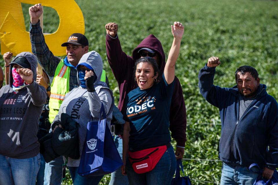 Luz Gallegos, executive director at the nonprofit TODEC, gathers for a photograph with farmworkers in Mecca on Nov. 22 to commemorate the holiday season. TODEC announced it would surprise farmworkers over the holidays with gifts like boots and jackets.