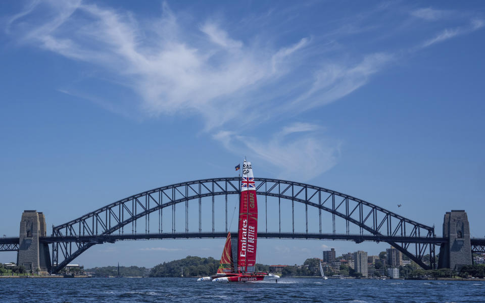 In a photo provided by SailGP, Emirates Great Britain SailGP, helmed by Ben Ainslie, sails past the Sydney Harbour Bridge during a practice session ahead of the Australia Sail Grand Prix in Sydney, Australia, Thursday, Feb. 16, 2023. (Bob Martin/SailGP via AP)